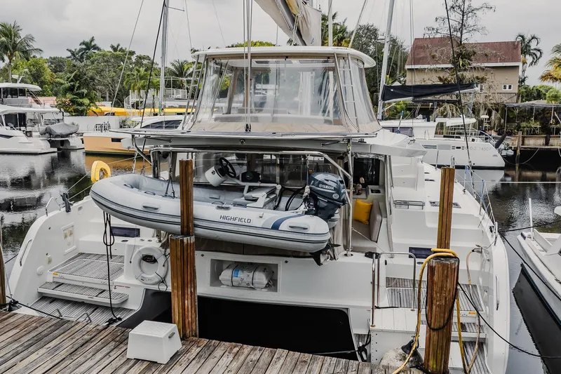 Slide: The Image of 2022 Lagoon 46 catamaran docked with inflatable boat and Yamaha motor. - 162