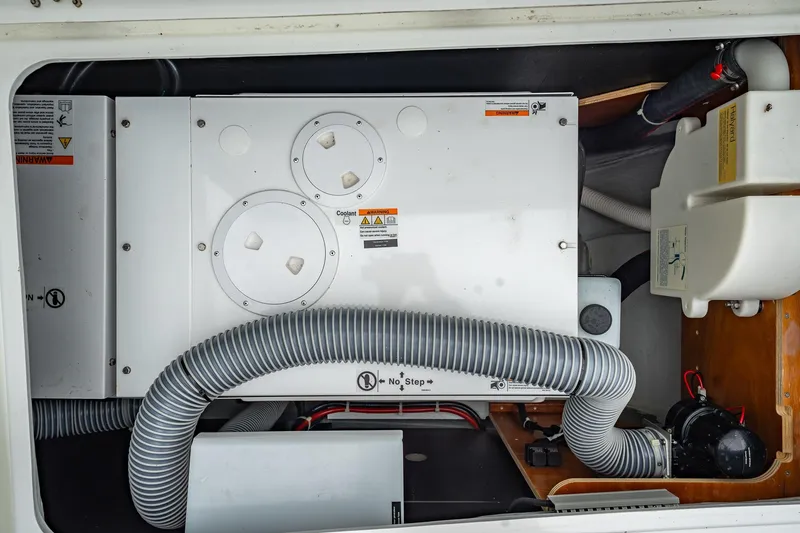 Slide: The Image of Engine compartment of a 2022 Lagoon 46 yacht, featuring mechanical components and hoses. - 164