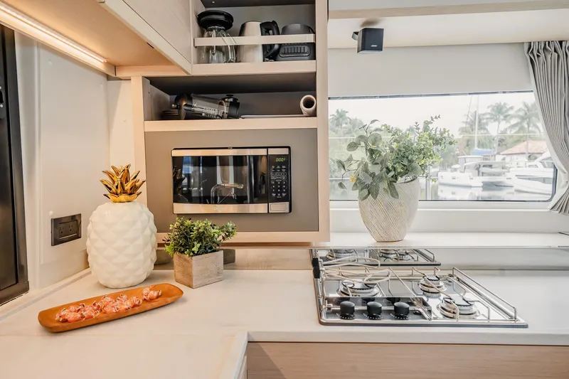 Slide: The Image of Modern kitchen interior of 2022 Lagoon 46 yacht with microwave and stove. - 19