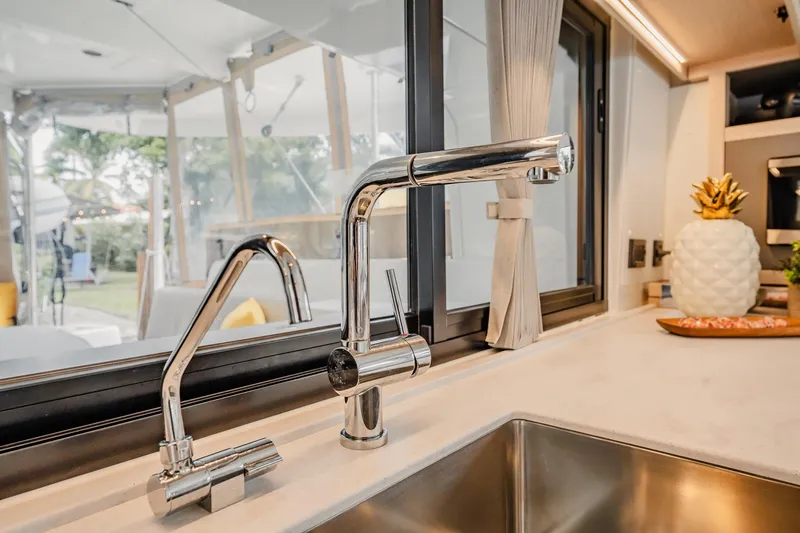 Slide: The Image of Modern kitchen sink with chrome faucets in 2022 Lagoon 46 yacht interior. - 20