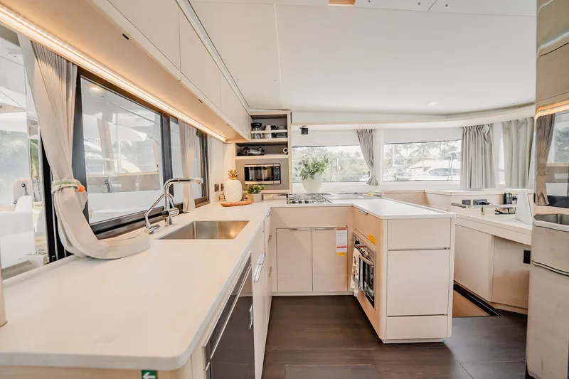 Slide: The Image of Modern kitchen interior of 2022 Lagoon 46 yacht with sleek countertops and ample natural light. - 26