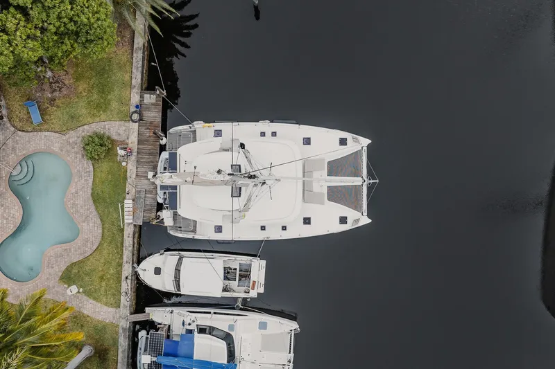 Slide: The Image of Aerial view of a 2022 Lagoon 46 catamaran docked near a pool and greenery. - 67