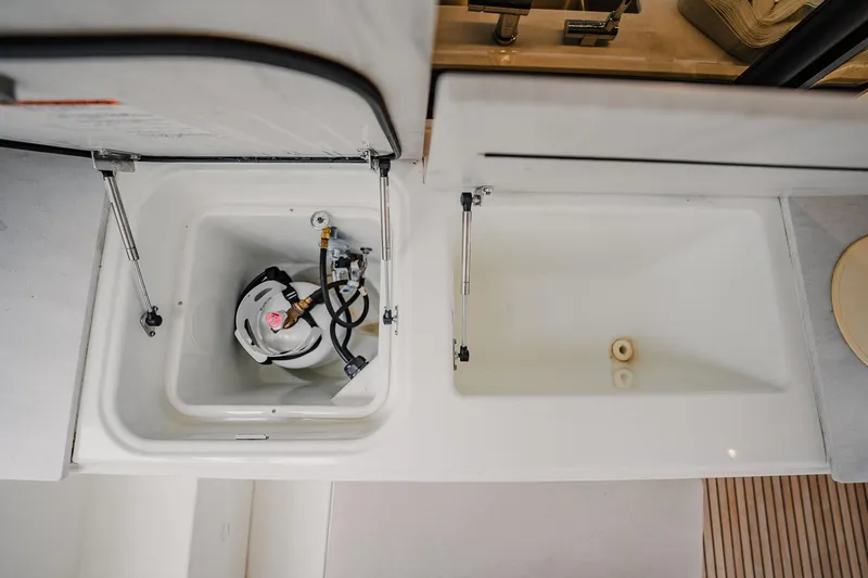 Slide: The Image of Storage compartments on a 2022 Lagoon 46 yacht, featuring a propane tank and empty space. - 80