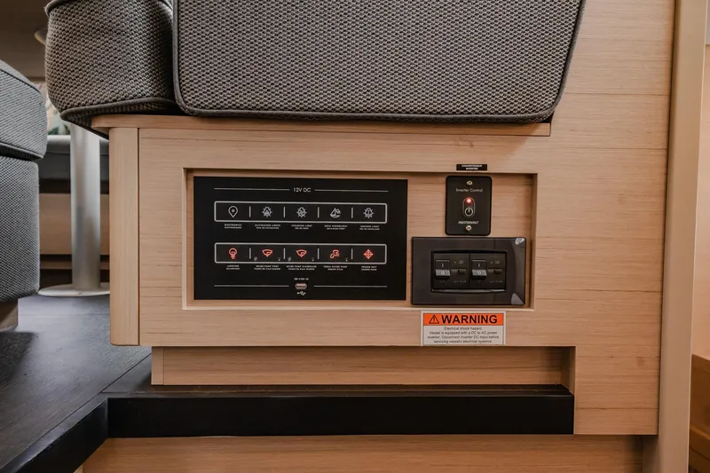 Slide: The Image of Control panel of 2022 Lagoon 46 yacht, featuring switches and warning label. - 91