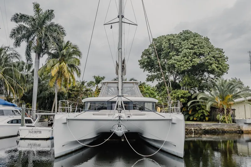 Slide: The Image of 2022 Lagoon 46 catamaran docked among tropical palm trees. - 93