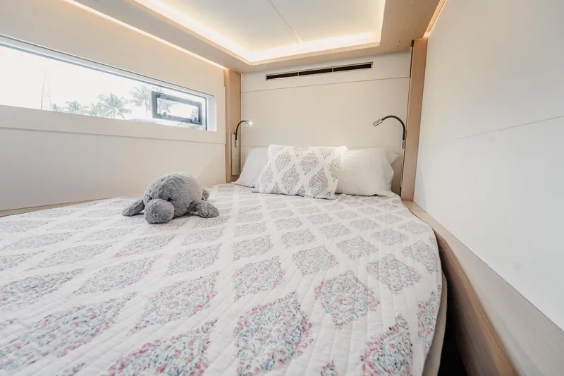Slide: The Image of Luxurious bedroom interior of 2022 Lagoon 46 yacht with plush bedding and soft lighting. - 98