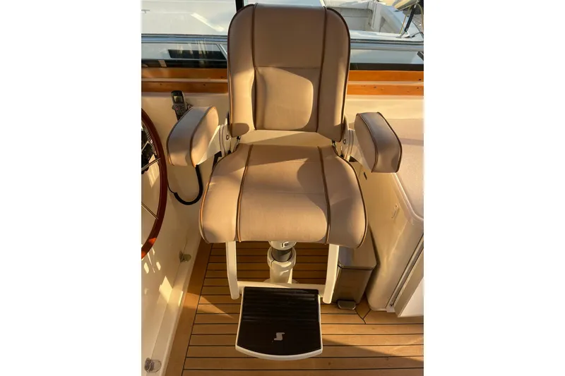 Slide: The Image of Captain's chair on 2008 Sabre 38 Salon Express yacht, featuring beige upholstery and wooden flooring. - 33