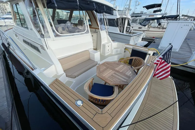 Slide: The Image of 2008 Sabre 38 Salon Express yacht with seating area and American flag at dock. - 43