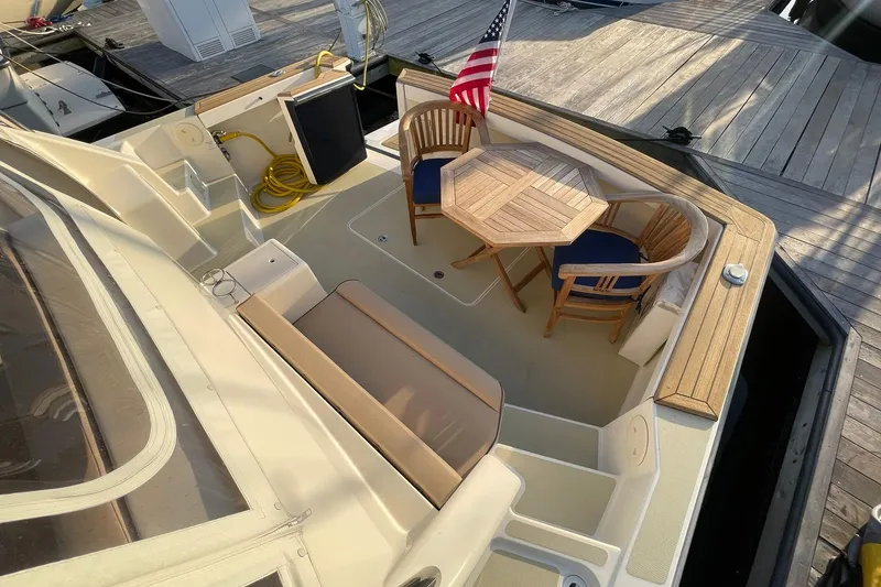 Slide: The Image of 2008 Sabre 38 Salon Express yacht deck with seating, table, and American flag. - 44