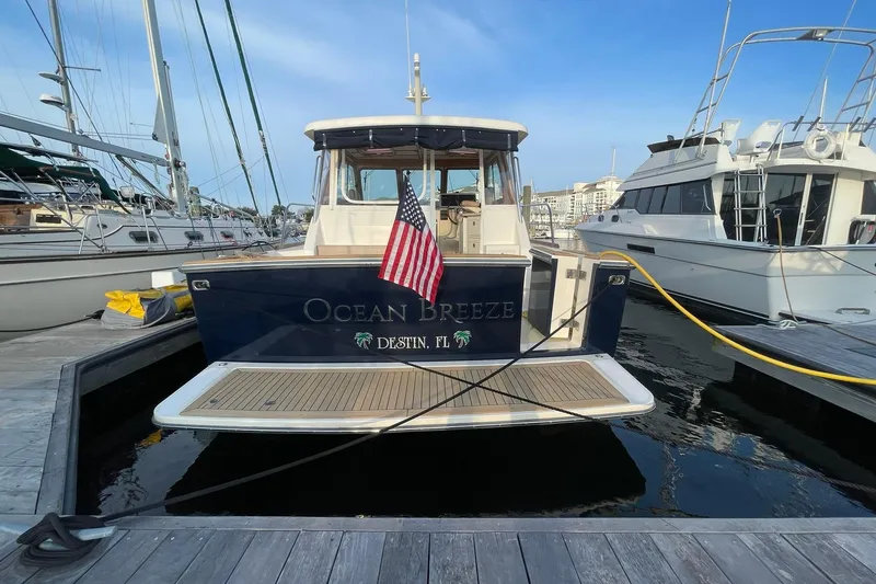 Slide: The Image of 2008 Sabre 38 Salon Express yacht docked, displaying "Ocean Breeze" and American flag. - 79