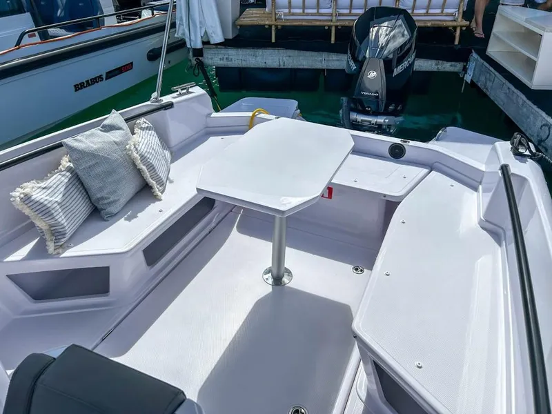 Slide: The Image of 2024 Axopar 25 Cross Top boat interior with seating and table. - 10