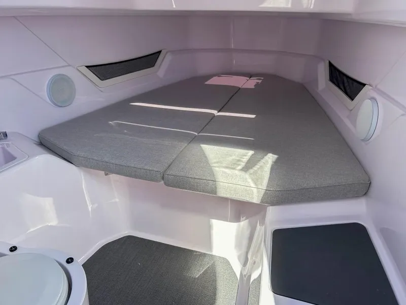 Slide: The Image of 2024 Axopar 25 Cross Top cabin interior with cushioned sleeping area. - 8