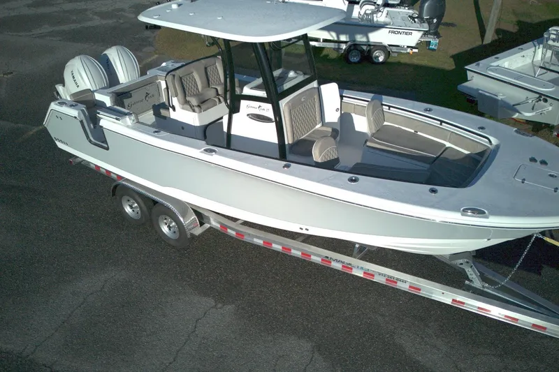 Slide: The Image of 2026 Sea Hunt Gamefish 27 Forward Seating boat on trailer, featuring dual engines and spacious seating. - 17