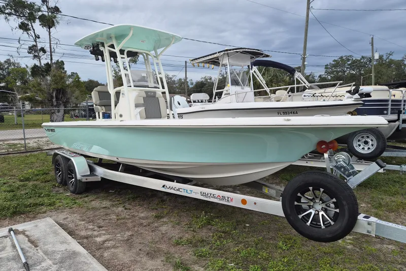 The Image of 2026 Key West 250 Bay Reef boat on trailer, light blue hull, parked outdoors. - 0