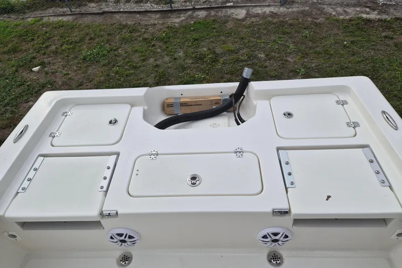 Slide: The Image of 2026 Key West 250 Bay Reef boat deck with storage compartments and speakers. - 12