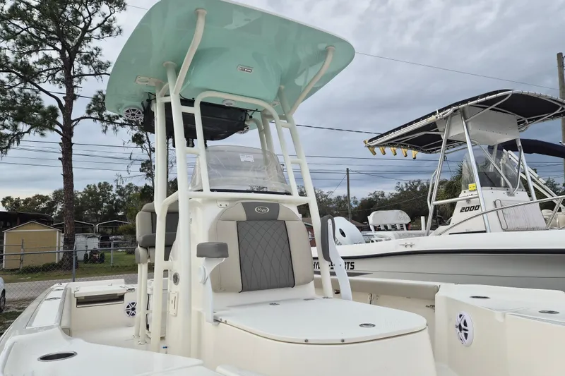 Slide: The Image of 2026 Key West 250 Bay Reef boat with T-top and seating, parked outdoors. - 2