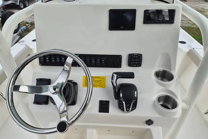 Slide: The Image of 2026 Key West 250 Bay Reef boat console with steering wheel, controls, and cup holders. - 8
