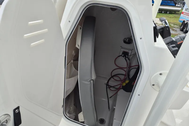Slide: The Image of 2026 Key West 250 Bay Reef boat storage compartment with wiring and seat cushion. - 9
