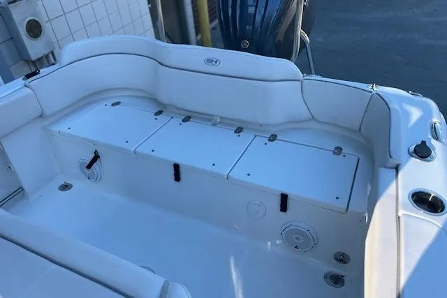 Slide: The Image of 2023 Sea Hunt Ultra 234 boat interior with white seating and storage compartments. - 10