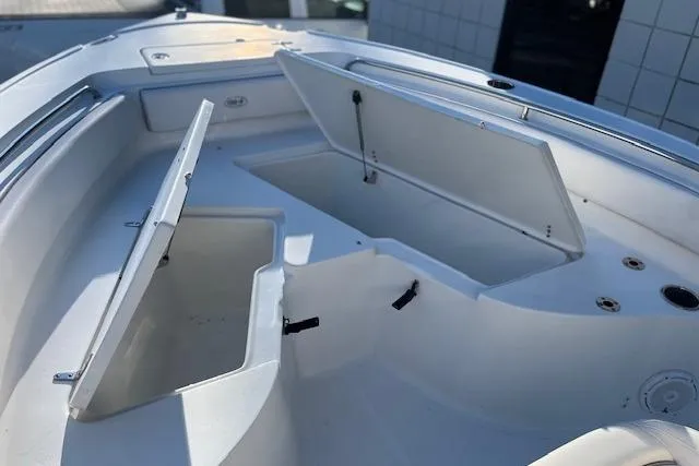 Slide: The Image of 2023 Sea Hunt Ultra 234 boat with open storage compartments on deck. - 12