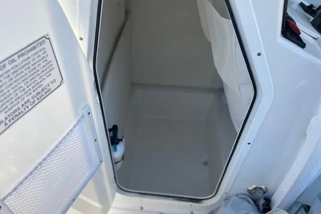 Slide: The Image of 2023 Sea Hunt Ultra 234 boat interior storage compartment with open door. - 16