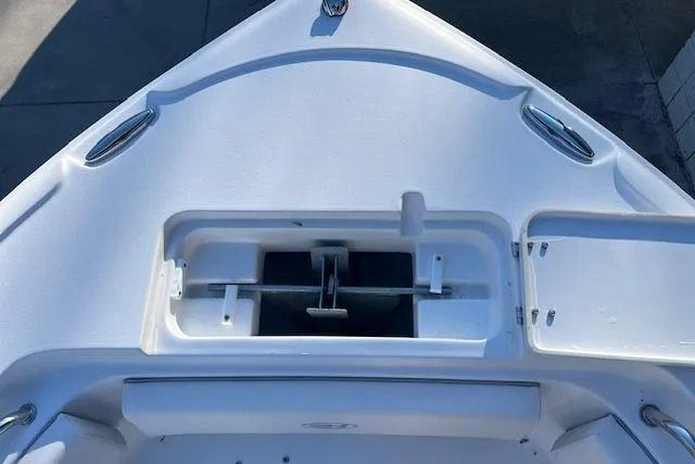 Slide: The Image of 2023 Sea Hunt Ultra 234 boat bow with open storage compartment. - 17