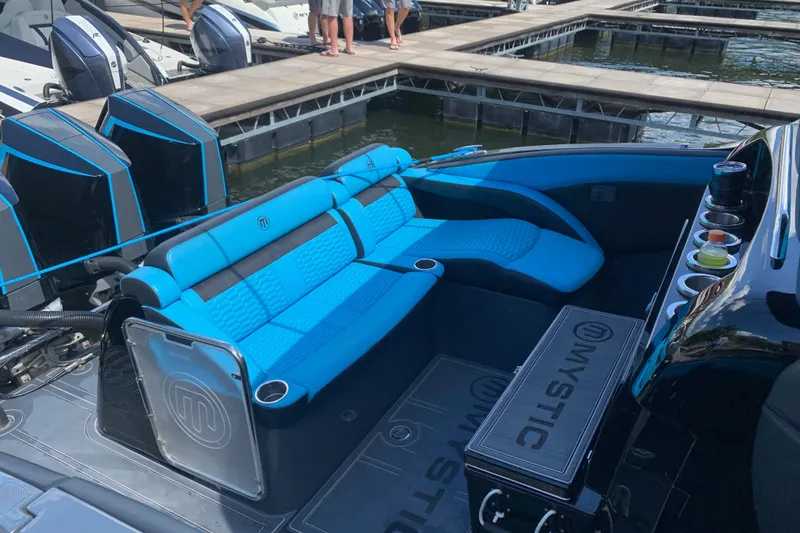 Slide: The Image of 2023 Mystic Powerboats M4200 with blue seating and powerful engines docked at marina. - 5