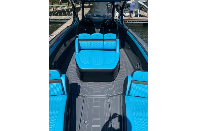 Slide: The Image of 2023 Mystic Powerboats M4200 with blue seating and sleek design at a dock. - 7
