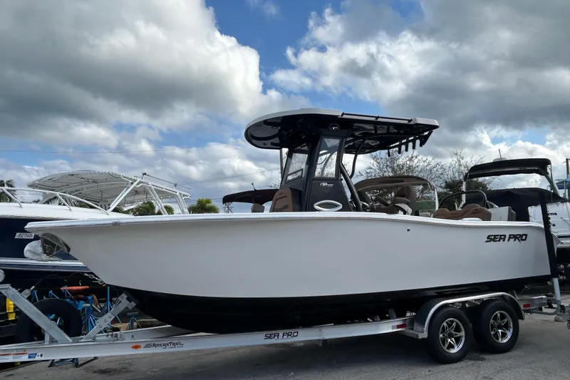 The Image of 2026 Sea Pro 245FLX Sandbar boat on trailer under cloudy sky. - 0