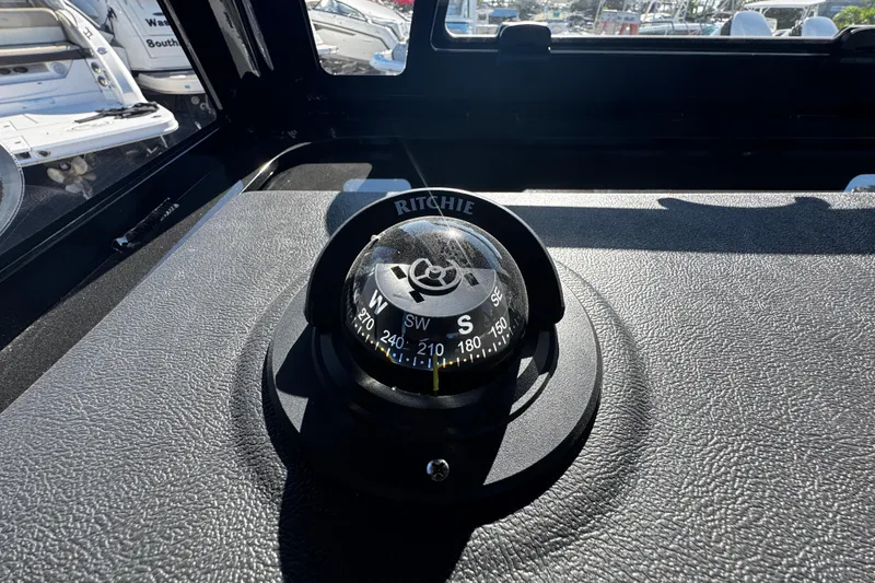 Slide: The Image of Compass on 2026 Sea Pro 245FLX Sandbar boat dashboard, surrounded by other boats. - 34