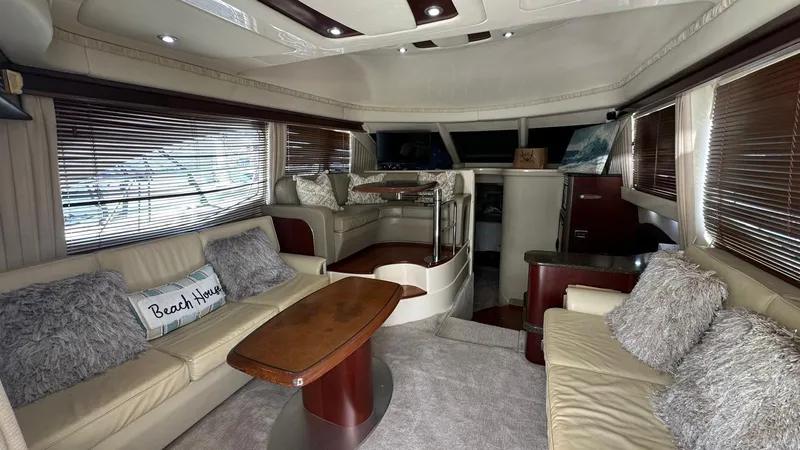 Slide: The Image of Luxurious interior of 2006 Sea Ray 44 Sedan Bridge yacht with plush seating and wooden accents. - 11