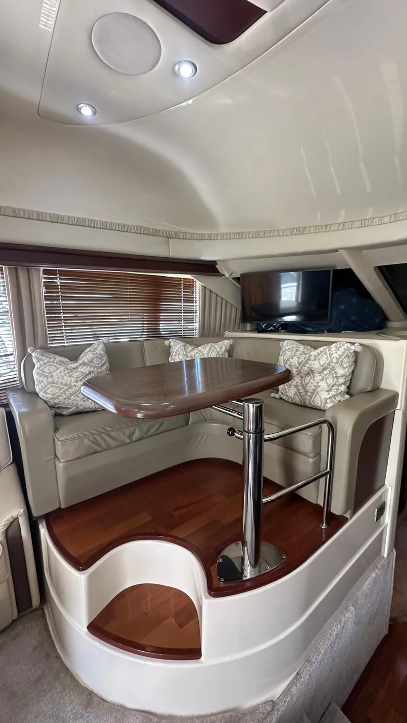 Slide: The Image of Luxurious interior of 2006 Sea Ray 44 Sedan Bridge with elegant seating and wooden table. - 14