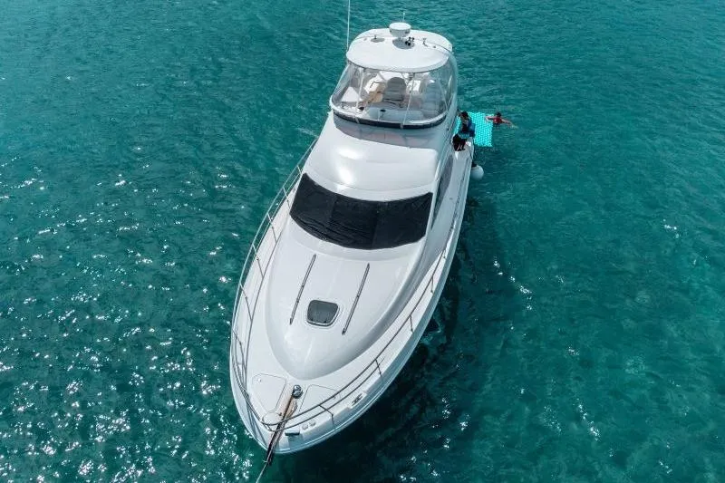 Slide: The Image of 2006 Sea Ray 44 Sedan Bridge yacht on clear turquoise water. - 2