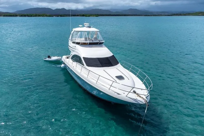Slide: The Image of 2006 Sea Ray 44 Sedan Bridge yacht anchored in clear blue water. - 3