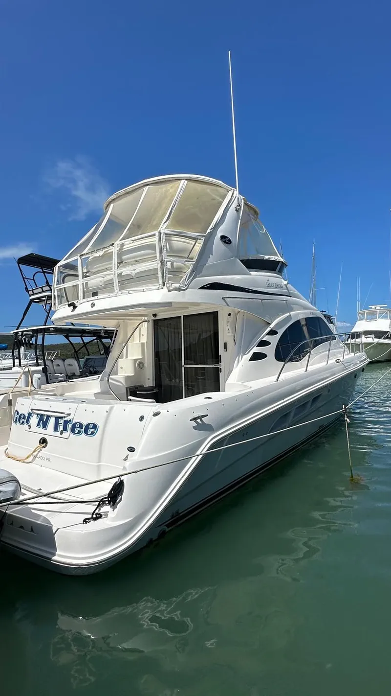 Slide: The Image of 2006 Sea Ray 44 Sedan Bridge yacht docked in marina under clear blue sky. - 6