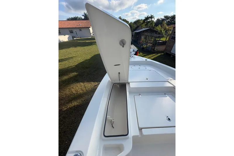 Slide: The Image of 2022 Pathfinder 2400 TRS boat with open storage compartment, outdoor setting. - 10