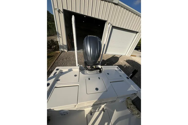 Slide: The Image of 2022 Pathfinder 2400 TRS boat with motor, parked outside a metal garage. - 14