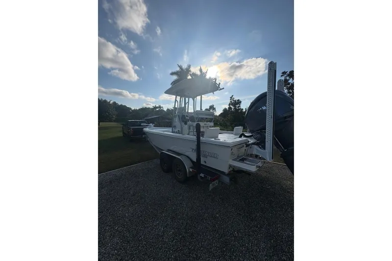 Slide: The Image of 2022 Pathfinder 2400 TRS boat on trailer, parked outdoors under a cloudy sky. - 16