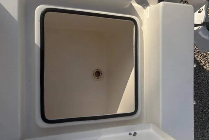 Slide: The Image of Open storage compartment on 2022 Pathfinder 2400 TRS boat, featuring a drain at the bottom. - 22