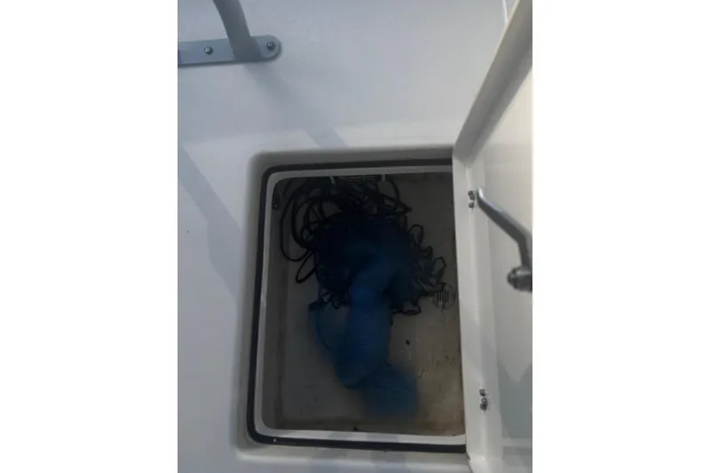 Slide: The Image of Open storage compartment on 2022 Pathfinder 2400 TRS boat with blue rope inside. - 24
