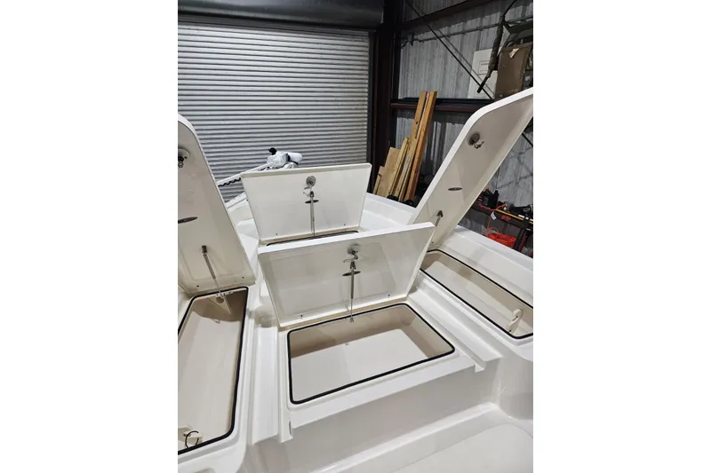 Slide: The Image of 2022 Pathfinder 2400 TRS boat storage compartments open in a garage setting. - 36