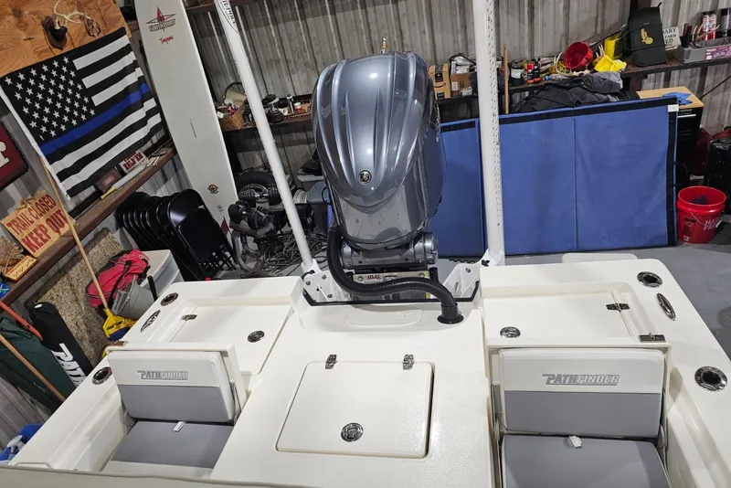 Slide: The Image of 2022 Pathfinder 2400 TRS boat in a garage with outboard motor and storage compartments. - 38