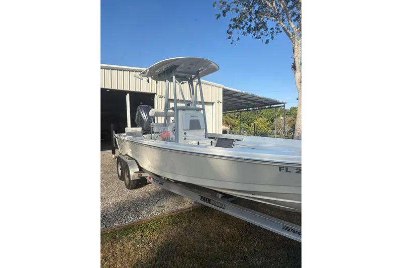 Slide: The Image of 2022 Pathfinder 2400 TRS boat on trailer near a metal building. - 6