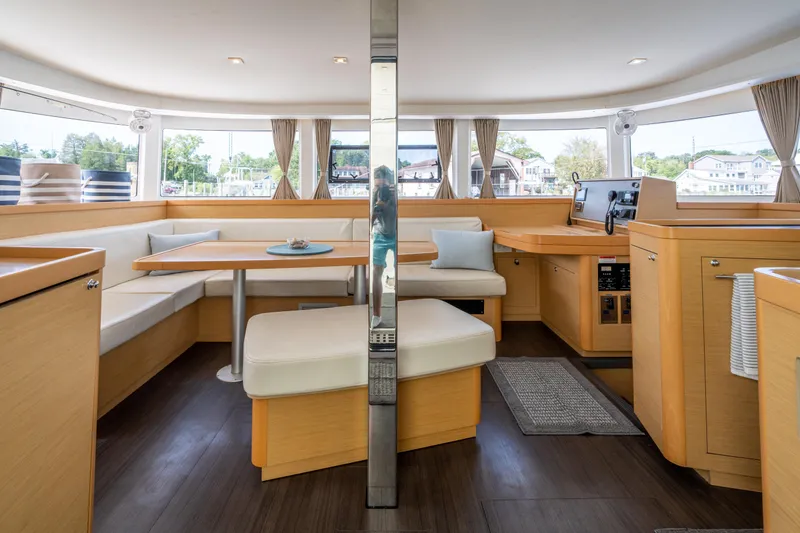 Slide: The Image of Interior of 2017 Lagoon 42 catamaran, featuring modern seating and panoramic windows. - 18