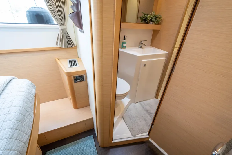 Slide: The Image of Interior of 2017 Lagoon 42 yacht featuring a compact bathroom and cozy cabin space. - 48