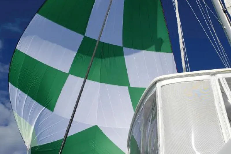 Slide: The Image of Green and white sail on a 2017 Lagoon 42 catamaran against a clear blue sky. - 79