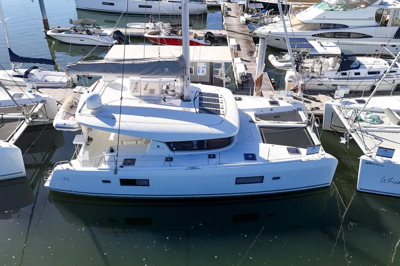 Slide: The Image of 2017 Lagoon 42 catamaran docked at marina, surrounded by other boats. - 84