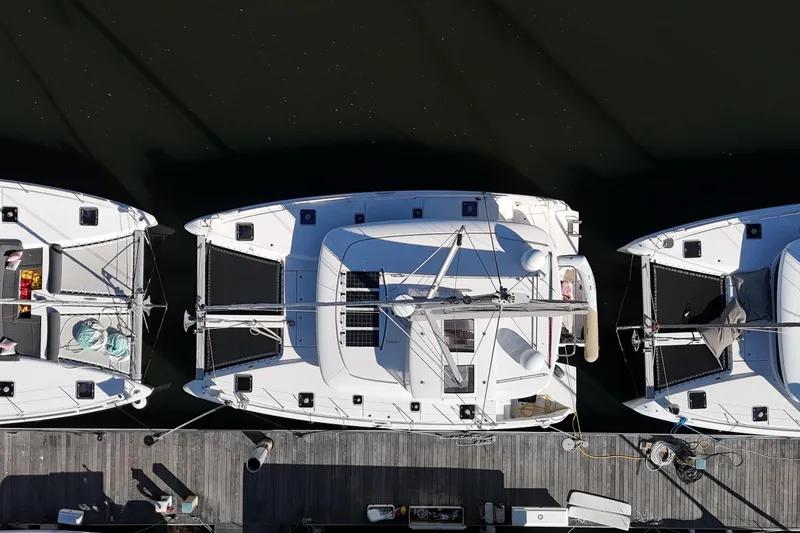 Slide: The Image of Overhead view of 2017 Lagoon 42 catamaran docked between two boats. - 89