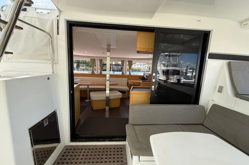 Slide: The Image of Interior view of a 2017 Lagoon 42 catamaran, featuring a modern seating area and dining space. - 96