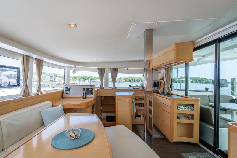 Slide: The Image of Interior of 2017 Lagoon 42 catamaran with modern kitchen and dining area, featuring panoramic windows. - 21
